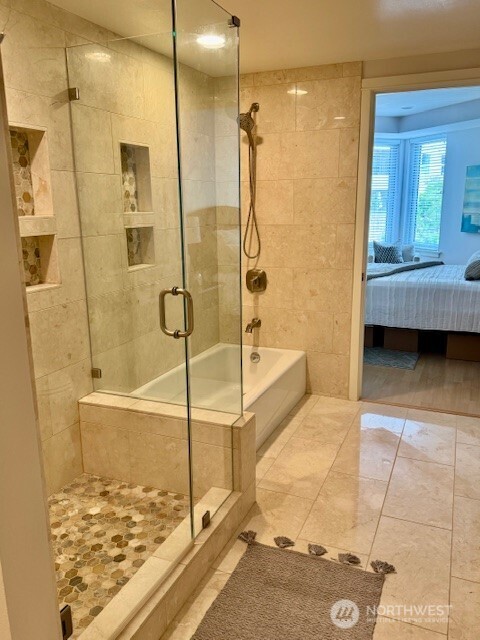 10047 Main Street, Unit 319 Bellevue, WA 98004 - Photo 24 of 30 a bathroom with a tub and a shower