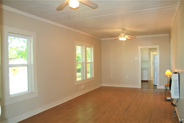 a view of empty room with window and chandelier fan