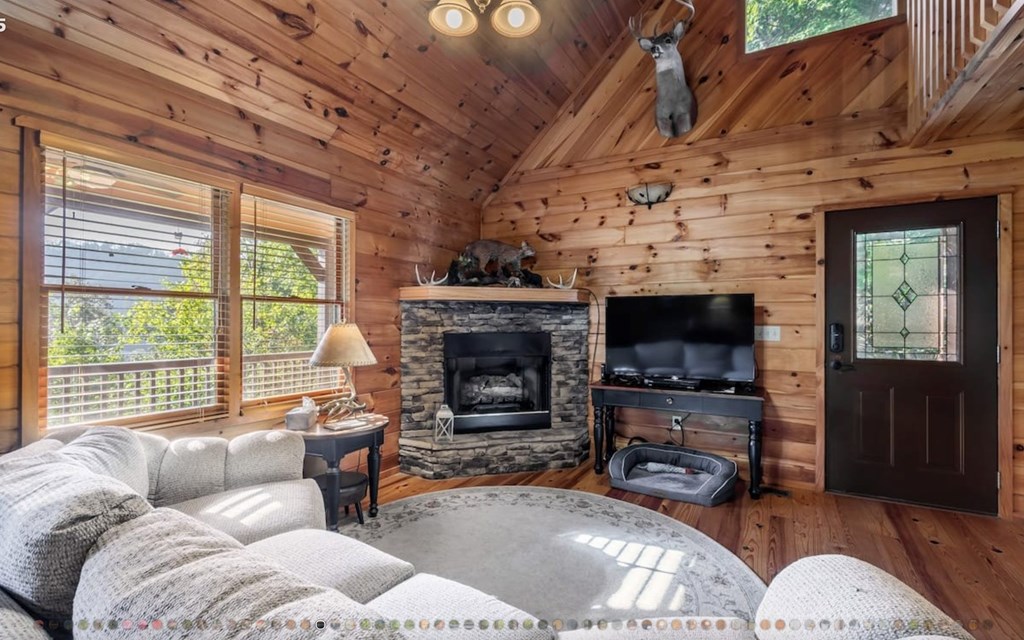335 Mountain Laurel Lane Blue Ridge, GA 30513 - Photo 7 of 67 a living room with furniture a fireplace wooden floor and a flat screen tv
