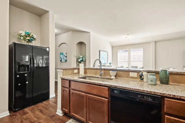 a kitchen with stainless steel appliances granite countertop a sink a stove and cabinets
