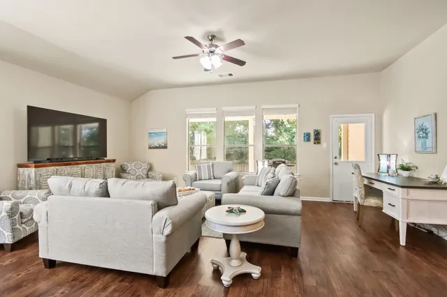 a living room with furniture and a flat screen tv with wooden floor