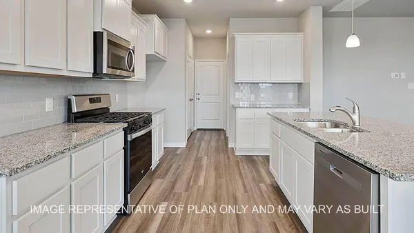a kitchen with granite countertop a sink stainless steel appliances and cabinets