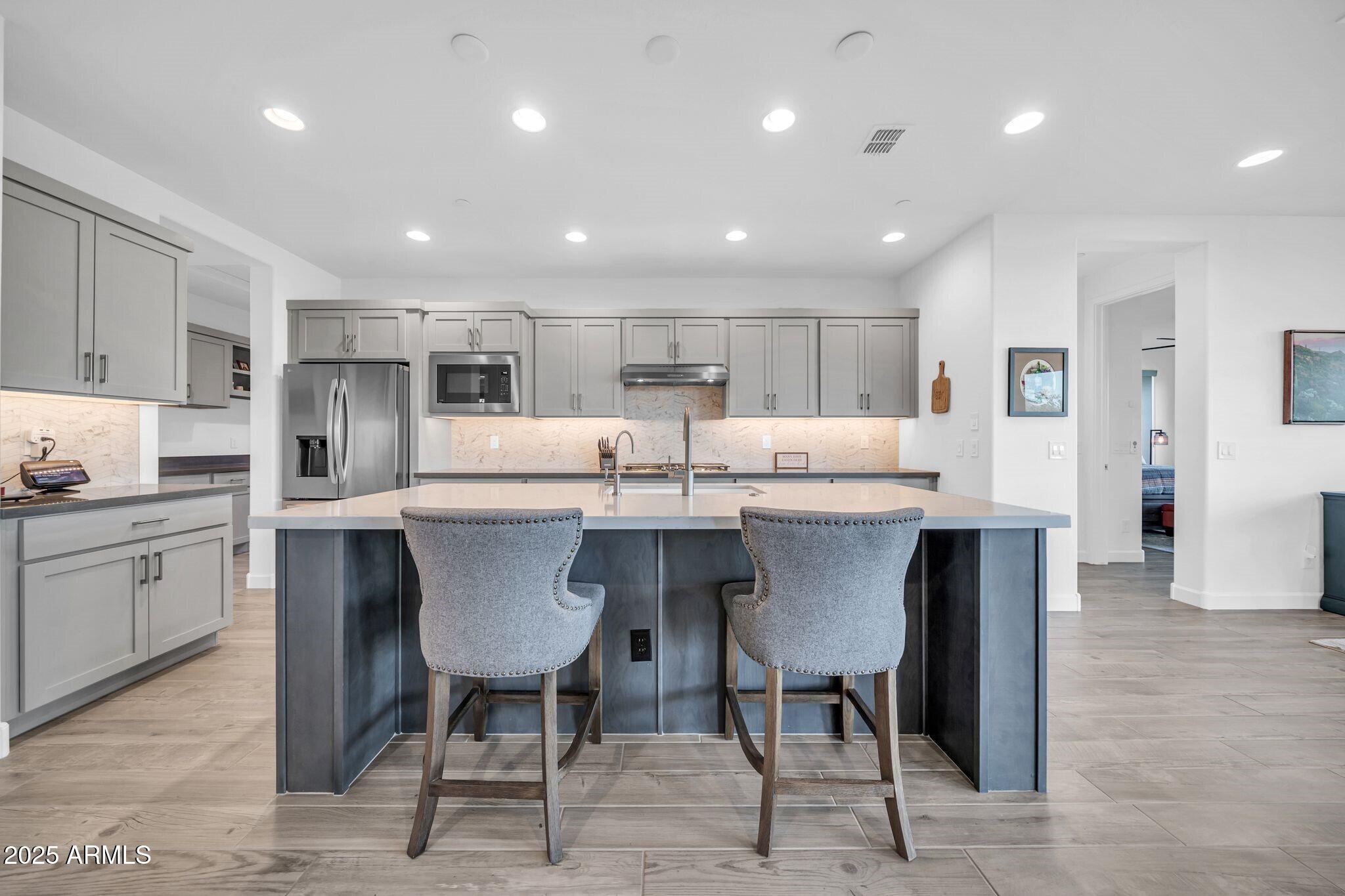 18212 East Parker Creek Road Rio Verde, AZ 85263 - Photo 10 of 47 a kitchen with stainless steel appliances kitchen island granite countertop a table chairs sink and cabinets