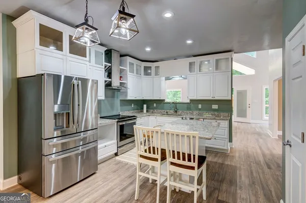 a kitchen with stainless steel appliances granite countertop a refrigerator and a stove top oven