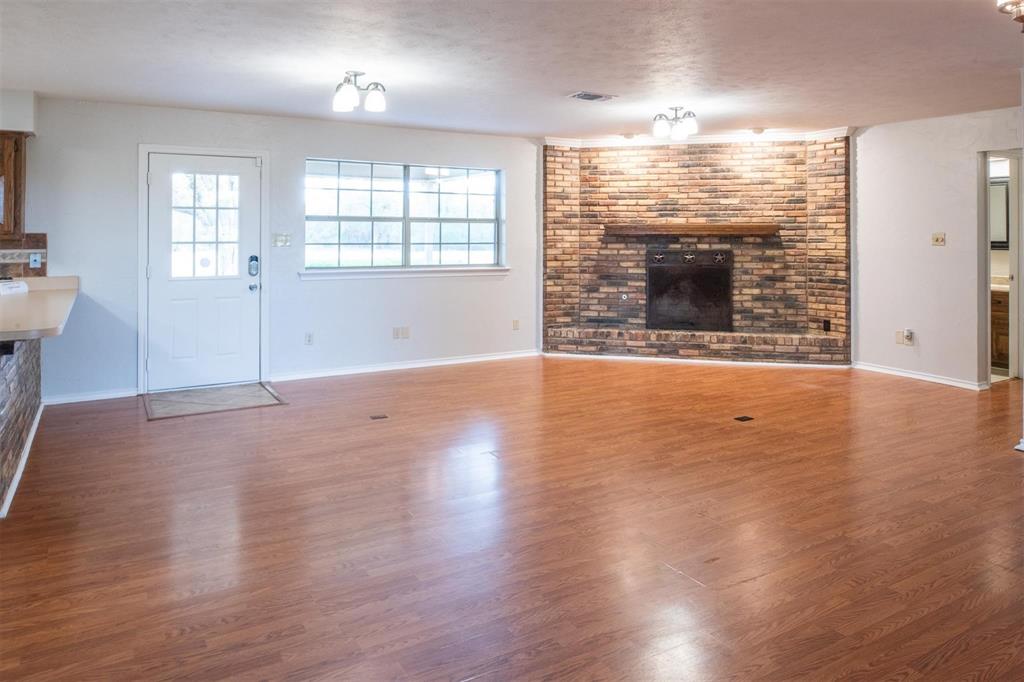 1850 Rock Ridge Road Lucas, TX 75002 - Photo 15 of 34 an empty room with wooden floor and fireplace