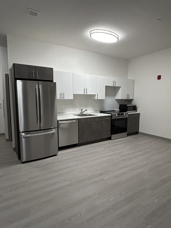 626 Main Street, Unit 110 Dennis, MA 02639 - Photo 3 of 14 a kitchen with stainless steel appliances granite countertop a refrigerator and a stove top oven