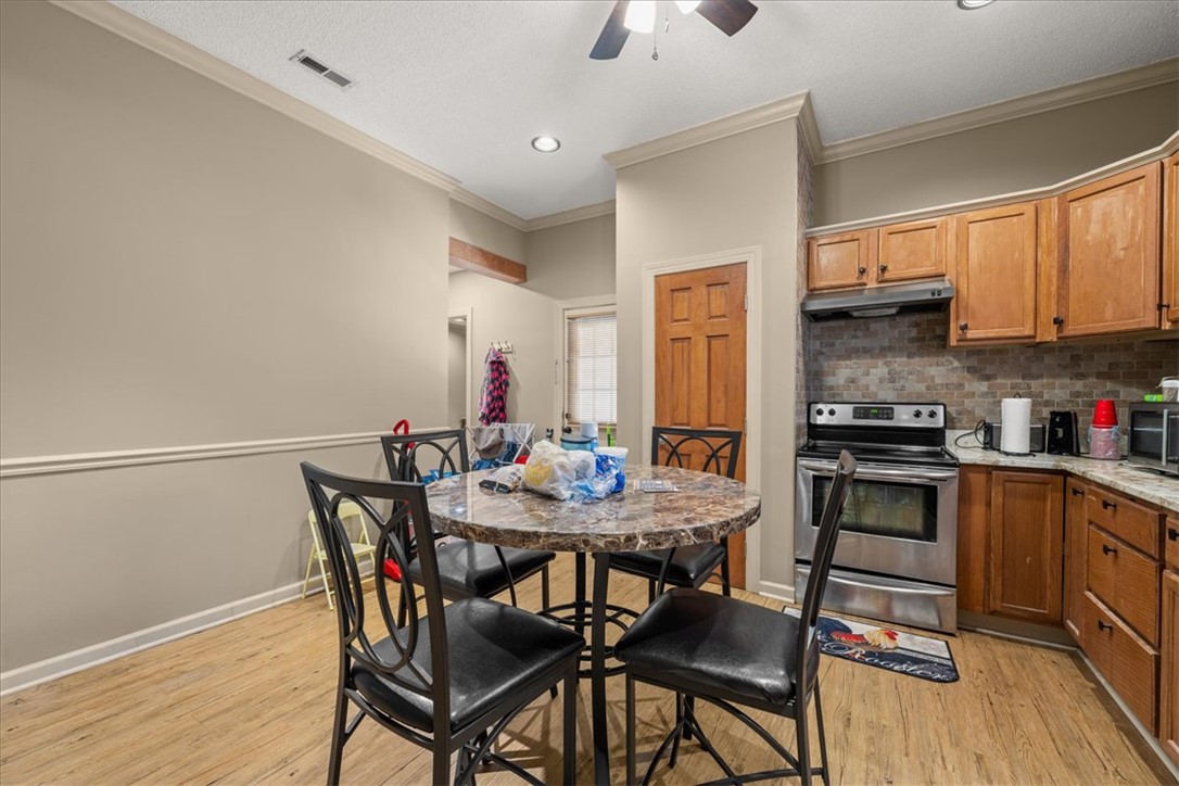 1102 West End Avenue Anderson, SC 29625 - Photo 9 of 28 A compact kitchen with warm wooden cabinetry and a well-appointed dining area offers functional living.