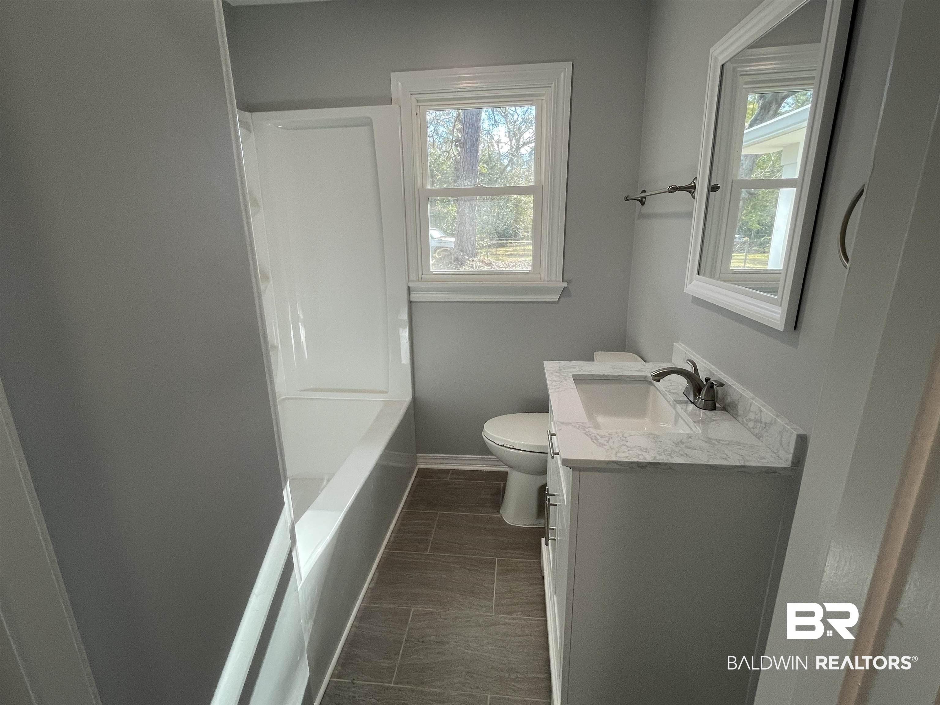 3901 Prima Vera Lane Mobile, AL 36605 - Photo 6 of 15 Bathroom with vanity, a tub, and toilet
