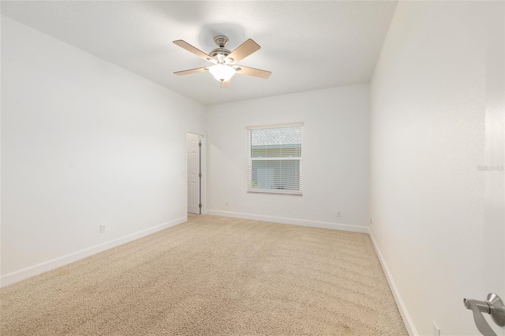 4735 Southeast 112th Street Road Belleview, FL 34420 - Photo 44 of 73 an empty room with a chandelier fan and windows