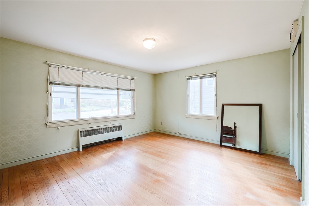 58 Cutler Drive Framingham, MA 01702 - Photo 17 of 35 a view of an empty room with wooden floor and a window