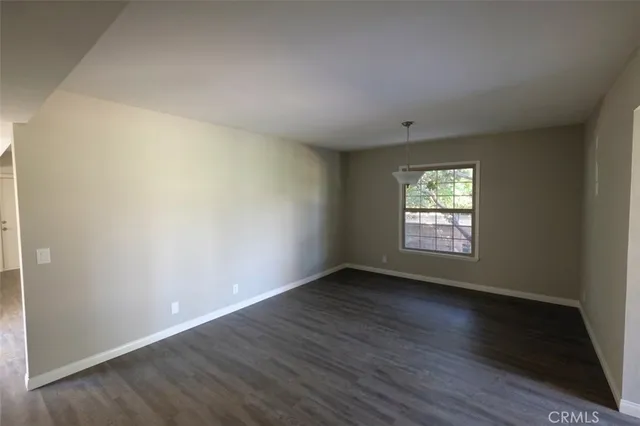 a view of a room with wooden floor and a window