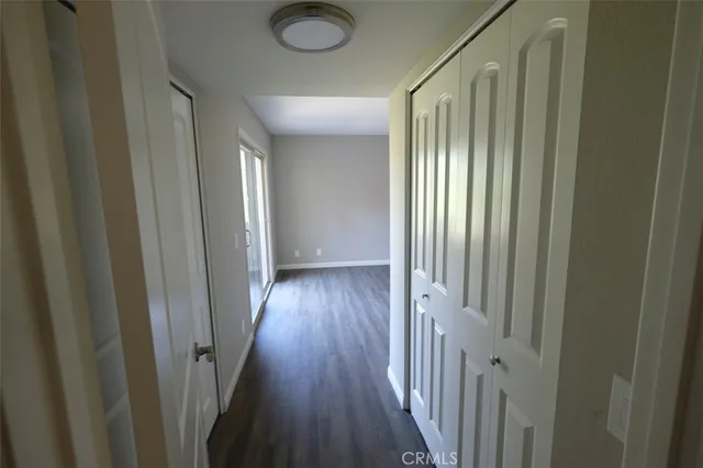 a view of a hallway with wooden floor and a window