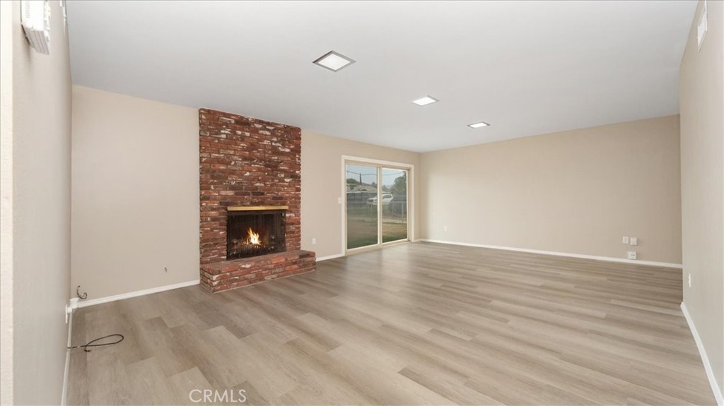 1607 Temescal Avenue Norco, CA 92860 - Photo 3 of 20 a view of an empty room with wooden floor fireplace and a window