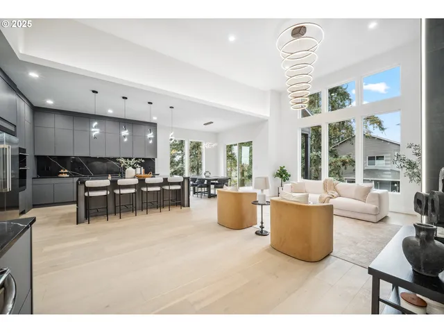 a living room with furniture kitchen view and a large window