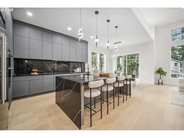 a kitchen with stainless steel appliances kitchen island granite countertop a dining table chairs and granite counter tops