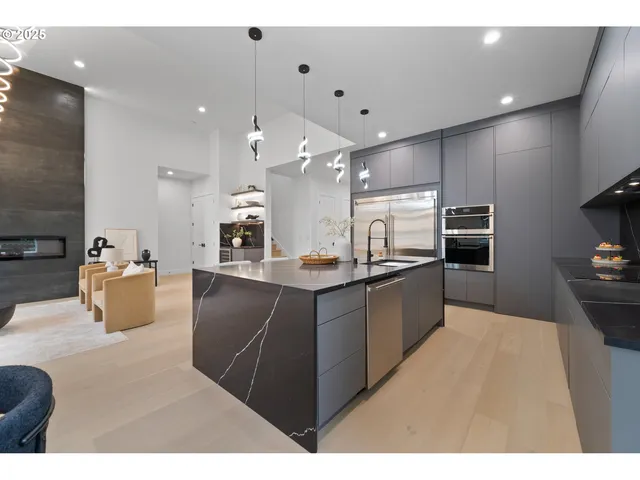 a large kitchen with stainless steel appliances kitchen island granite countertop a refrigerator a stove a sink and a oven