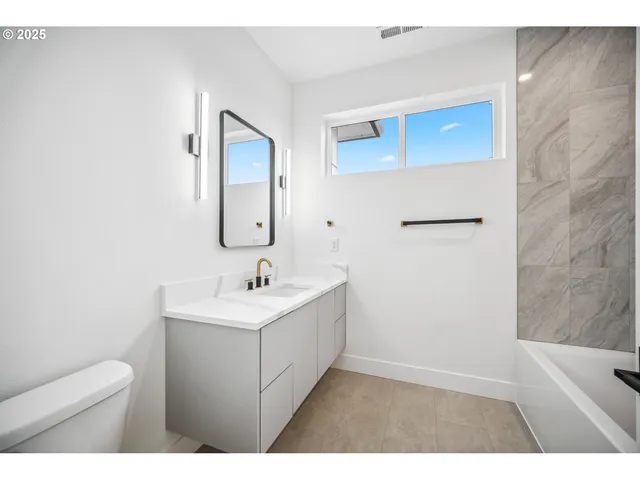a bathroom with a sink a toilet and mirror
