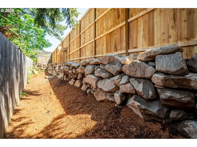 a view of a backyard with wooden fence