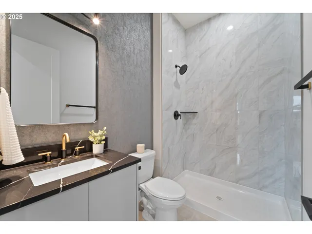 a bathroom with a sink a toilet and shower