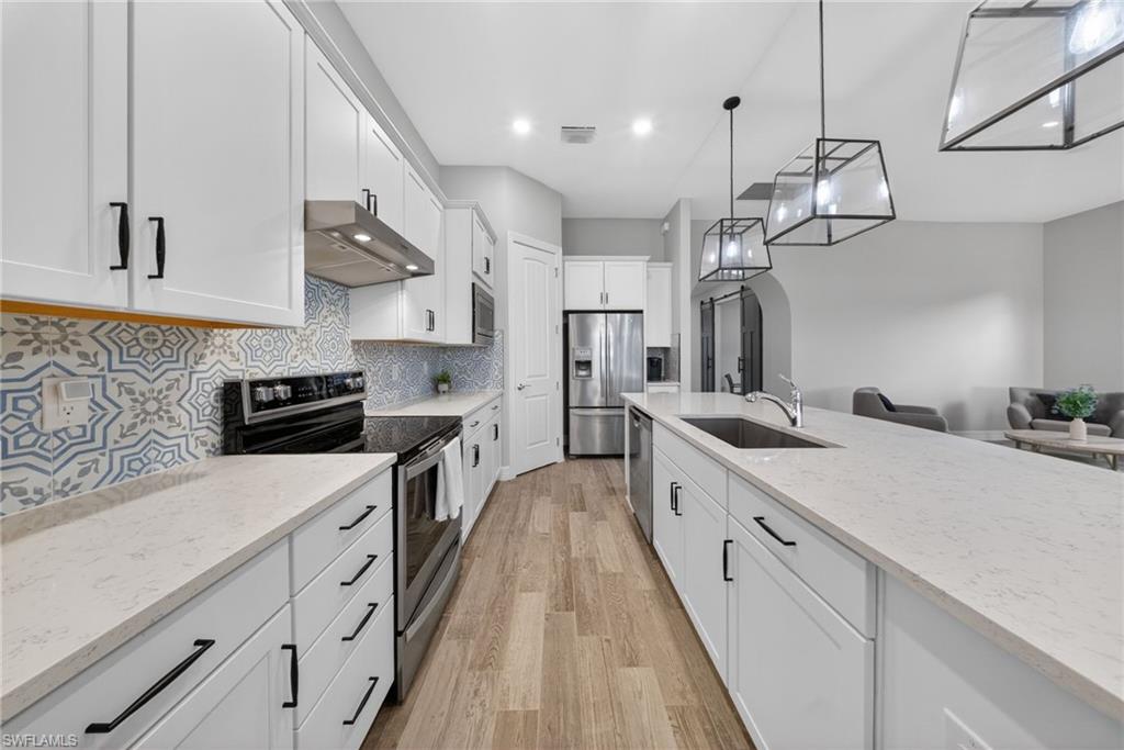 11920 Bourke Place Fort Myers, FL 33913 - Photo 12 of 45 a large kitchen with stainless steel appliances lots of counter space and a sink