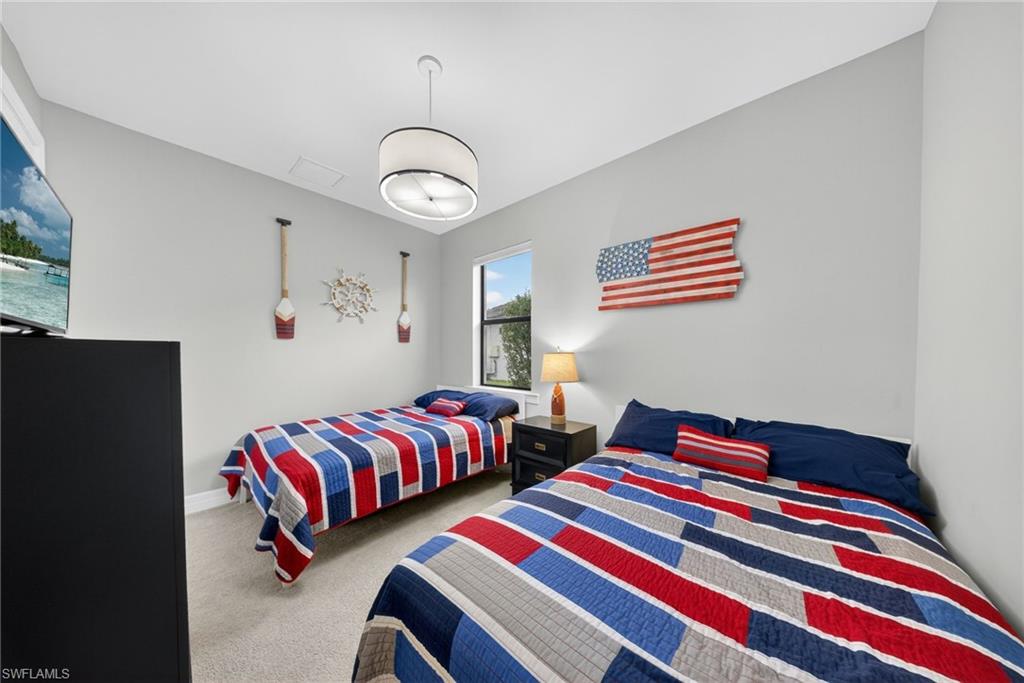 11920 Bourke Place Fort Myers, FL 33913 - Photo 27 of 45 a bedroom with two beds and a chandelier