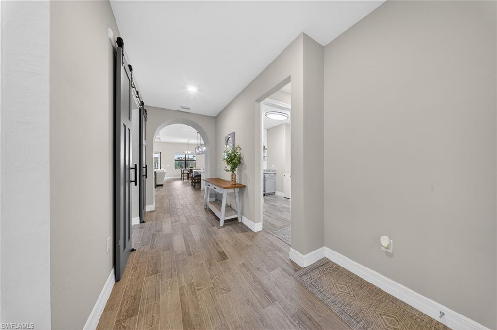 11920 Bourke Place Fort Myers, FL 33913 - Photo 29 of 45 a view of a hallway with wooden floor a glass table and chairs