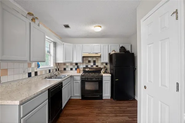 a kitchen with a sink dishwasher a refrigerator and a stove