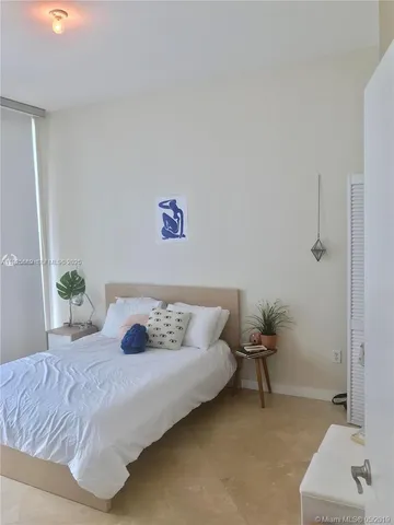 a bedroom with a bed and a potted plant