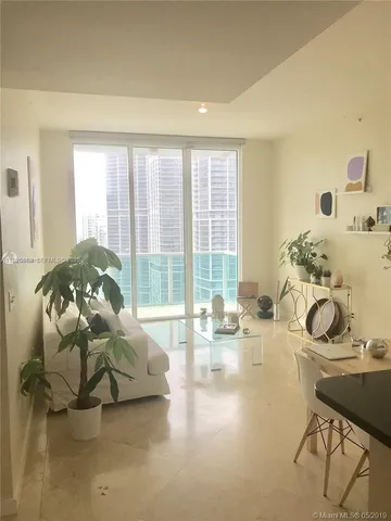 a bedroom with furniture and a large window