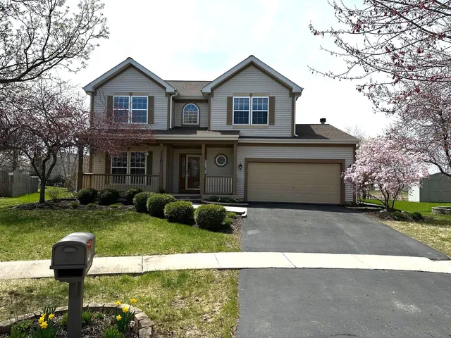 a view of a house with a yard and large tree