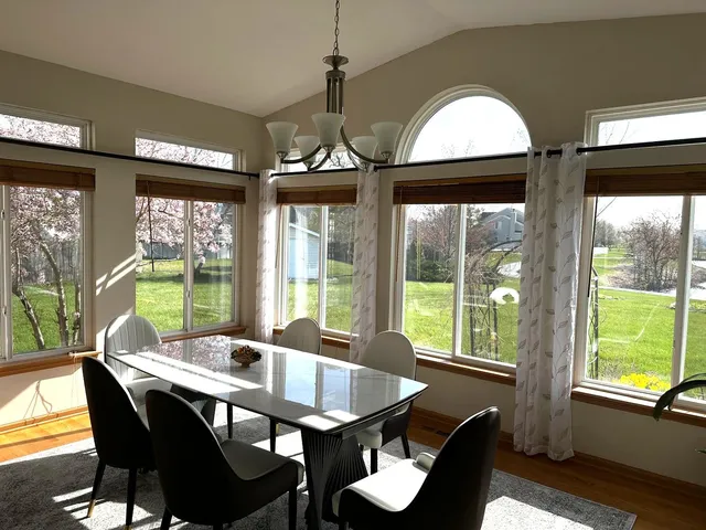 a view of a dining room with furniture large windows and wooden floor