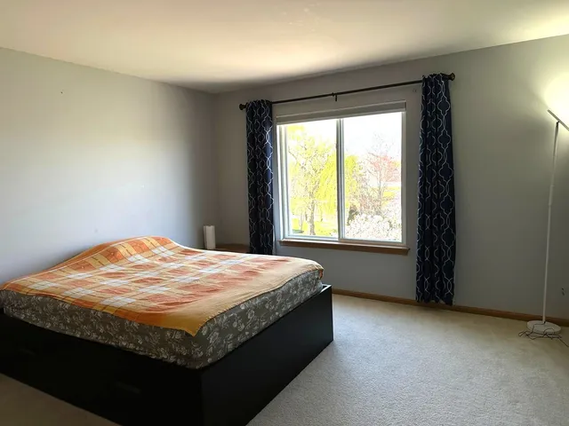 a bed sitting in a bedroom next to a window