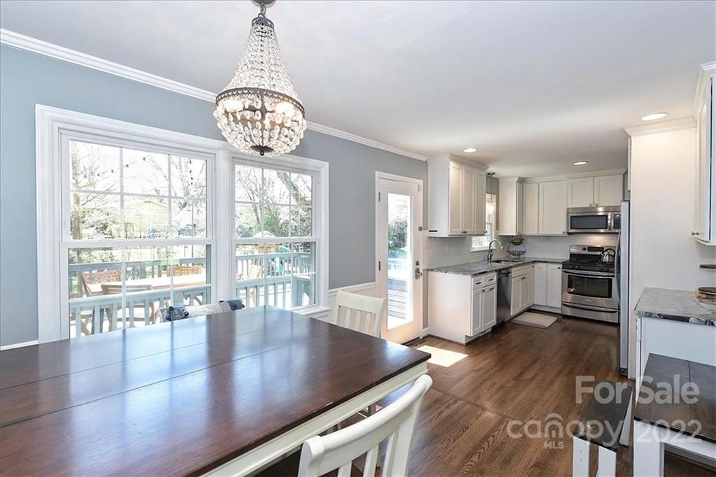3616 Round Oak Road Charlotte, NC 28210 - Photo 11 of 48 a open kitchen with granite countertop a stove dining table chairs and a large window