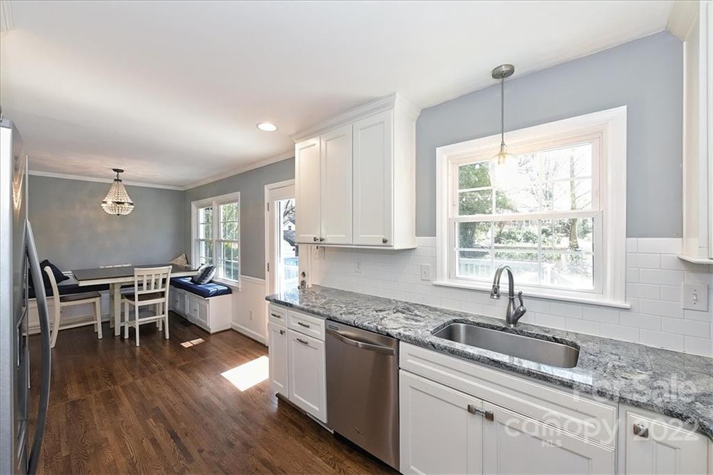 3616 Round Oak Road Charlotte, NC 28210 - Photo 17 of 48 a kitchen with granite countertop a stove a sink a dining table and chairs with wooden floor