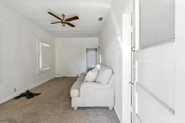 a living room with furniture and a ceiling fan