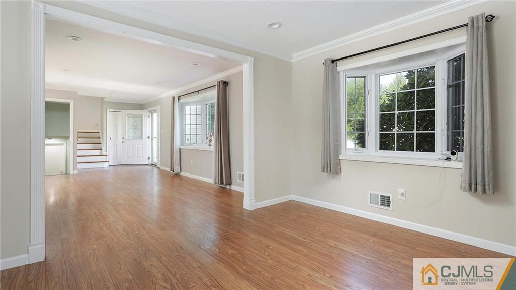 1884 Holly Road North Brunswick, NJ 08902 - Photo 12 of 39 a view of an empty room with wooden floor and a window