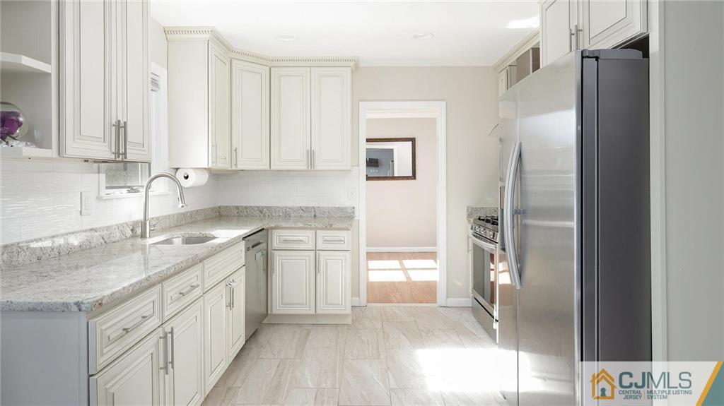 1884 Holly Road North Brunswick, NJ 08902 - Photo 15 of 39 a kitchen with a sink stove and refrigerator