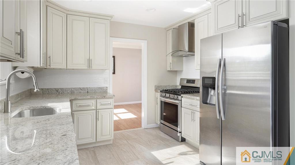 1884 Holly Road North Brunswick, NJ 08902 - Photo 16 of 39 a kitchen with a refrigerator sink and stove