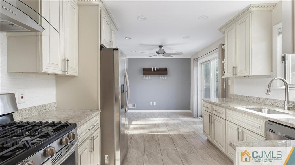1884 Holly Road North Brunswick, NJ 08902 - Photo 17 of 39 a kitchen with stainless steel appliances granite countertop a sink stove and refrigerator