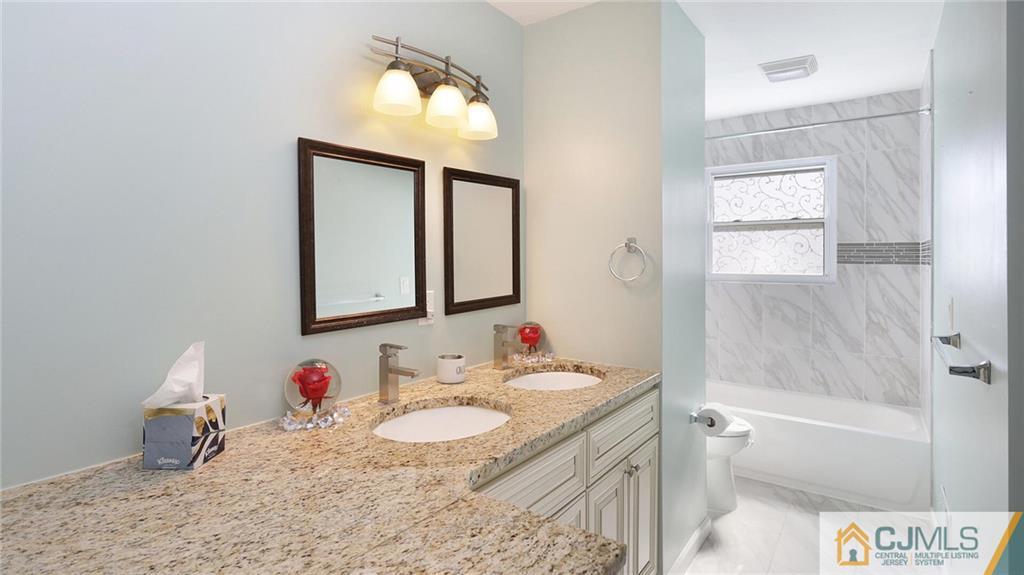1884 Holly Road North Brunswick, NJ 08902 - Photo 22 of 39 a bathroom with a granite countertop sink and a mirror