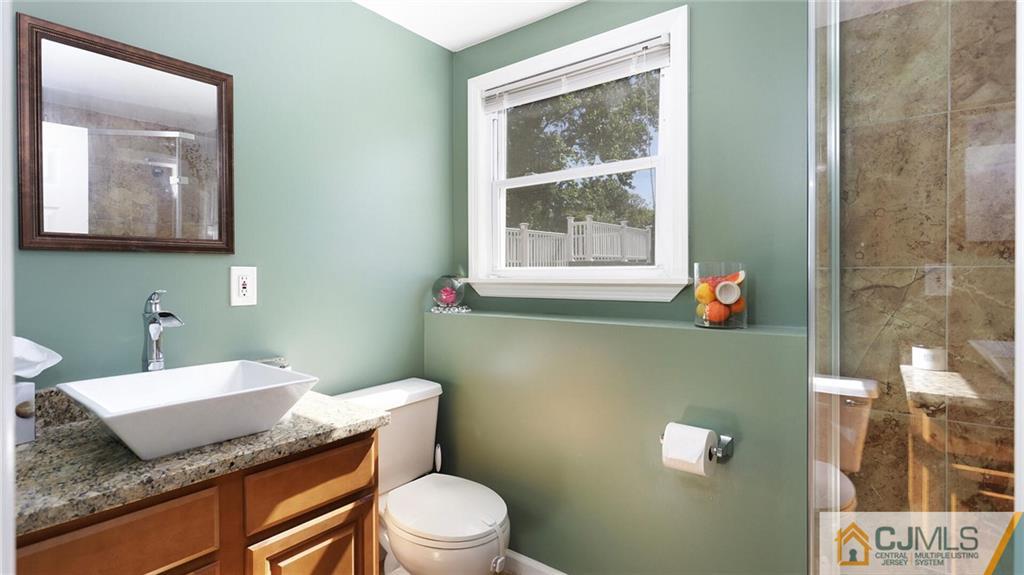 1884 Holly Road North Brunswick, NJ 08902 - Photo 29 of 39 a bathroom with a granite countertop toilet sink and mirror