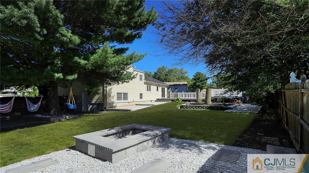 1884 Holly Road North Brunswick, NJ 08902 - Photo 33 of 39 a view of a white house with a yard plants and large tree