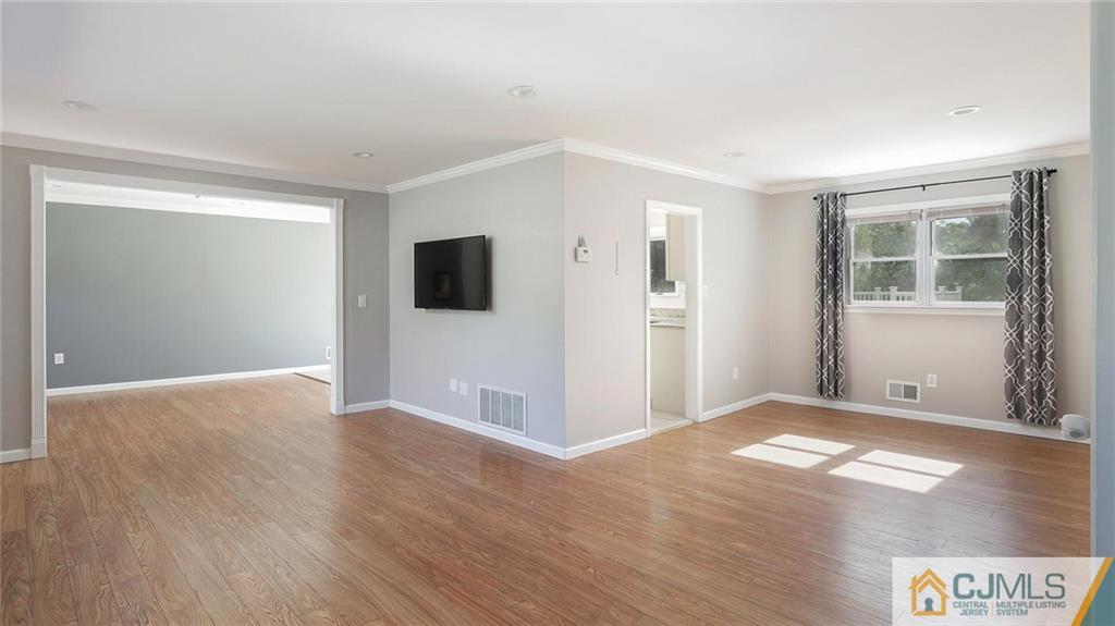 1884 Holly Road North Brunswick, NJ 08902 - Photo 8 of 39 a view of an empty room with wooden floor and a window