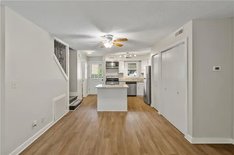 a view of a kitchen with wooden floor and a refrigerator