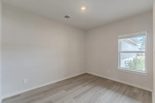 a view of an empty room and wooden floor