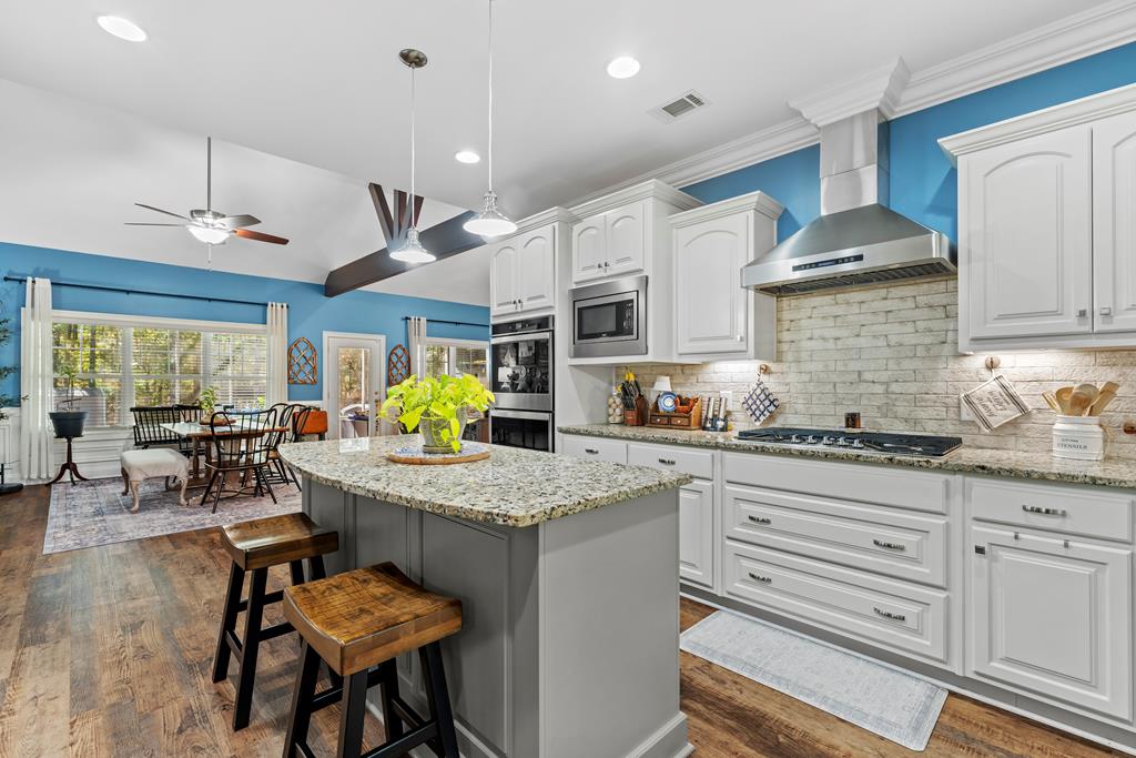 2800 Hopewell Church Road Pine Mountain, GA 31822 - Photo 16 of 38 a kitchen with stainless steel appliances granite countertop a stove a sink dishwasher a dining table and chairs with wooden floor