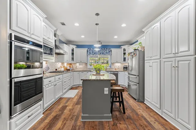a kitchen with refrigerator cabinets and wooden floor