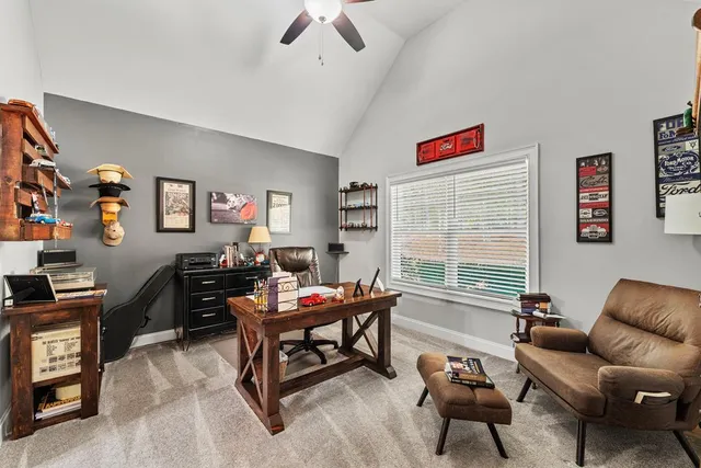 a living room with furniture a desk and a flat screen tv