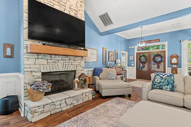 a living room with furniture a flat screen tv and a fireplace