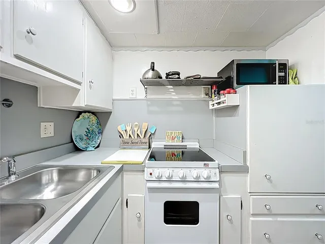 a kitchen with a stove and white cabinets
